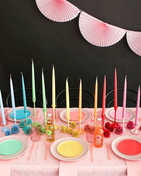 Table setting with rainbow colored candle wedding centerpieces and holders