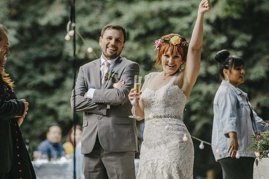 A wedding couple cheer during their wedding toasts