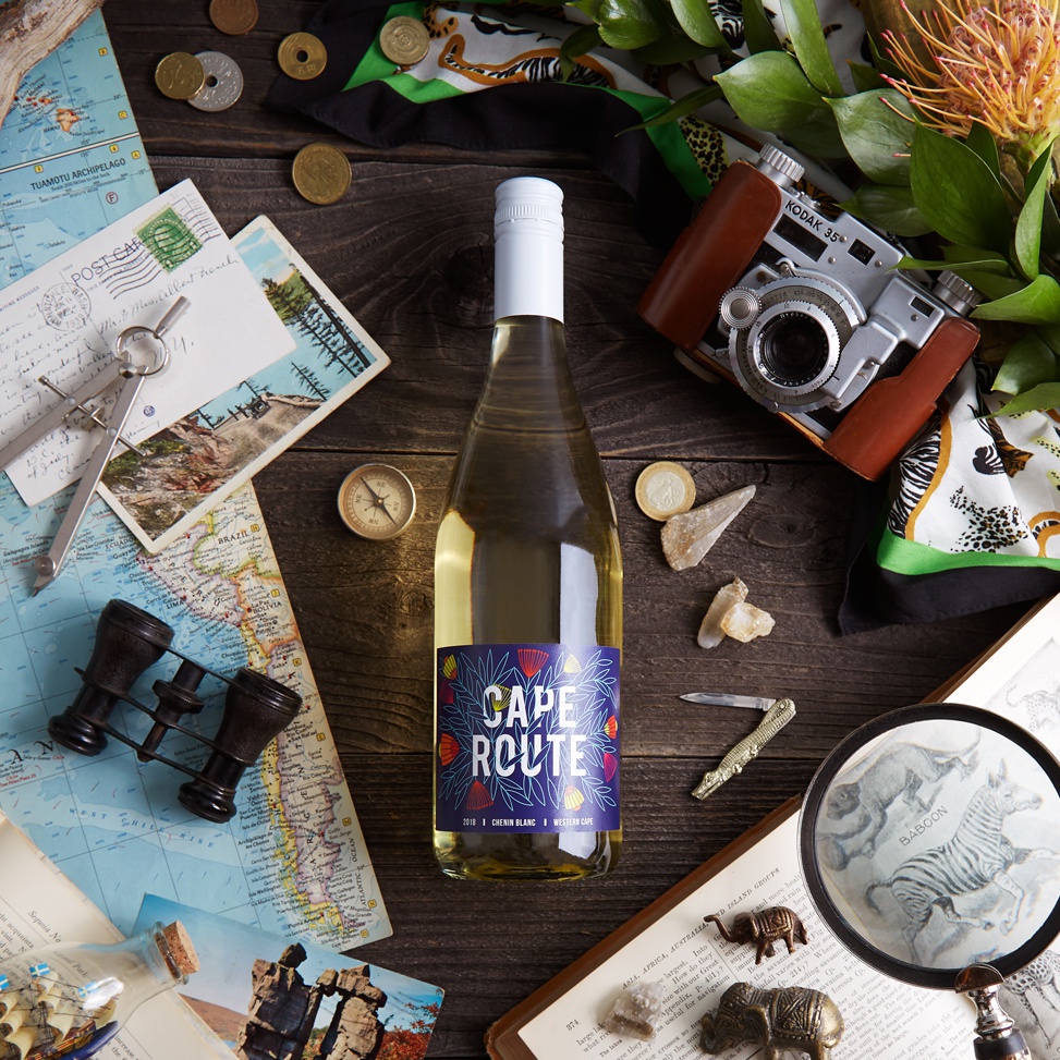 A photo of Cape Route Winc wine set on a table with travel kitsch