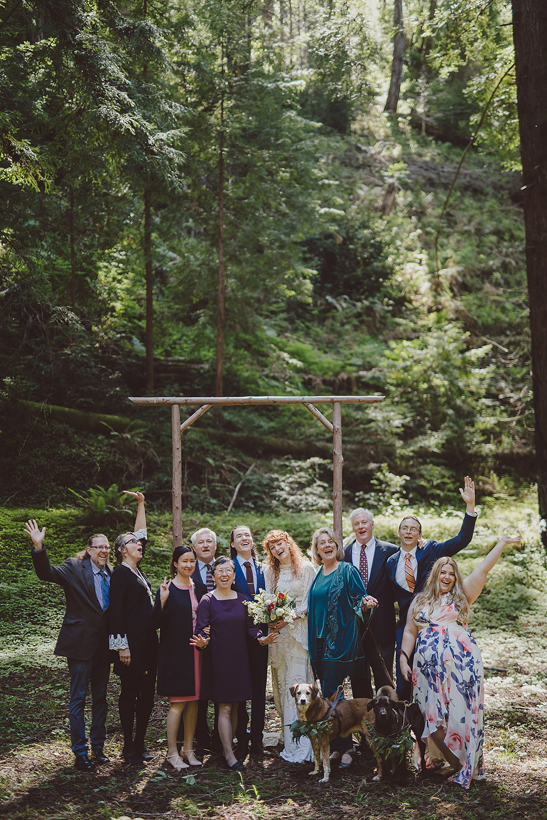 A wedding couple and their families stand for a casual photo together.