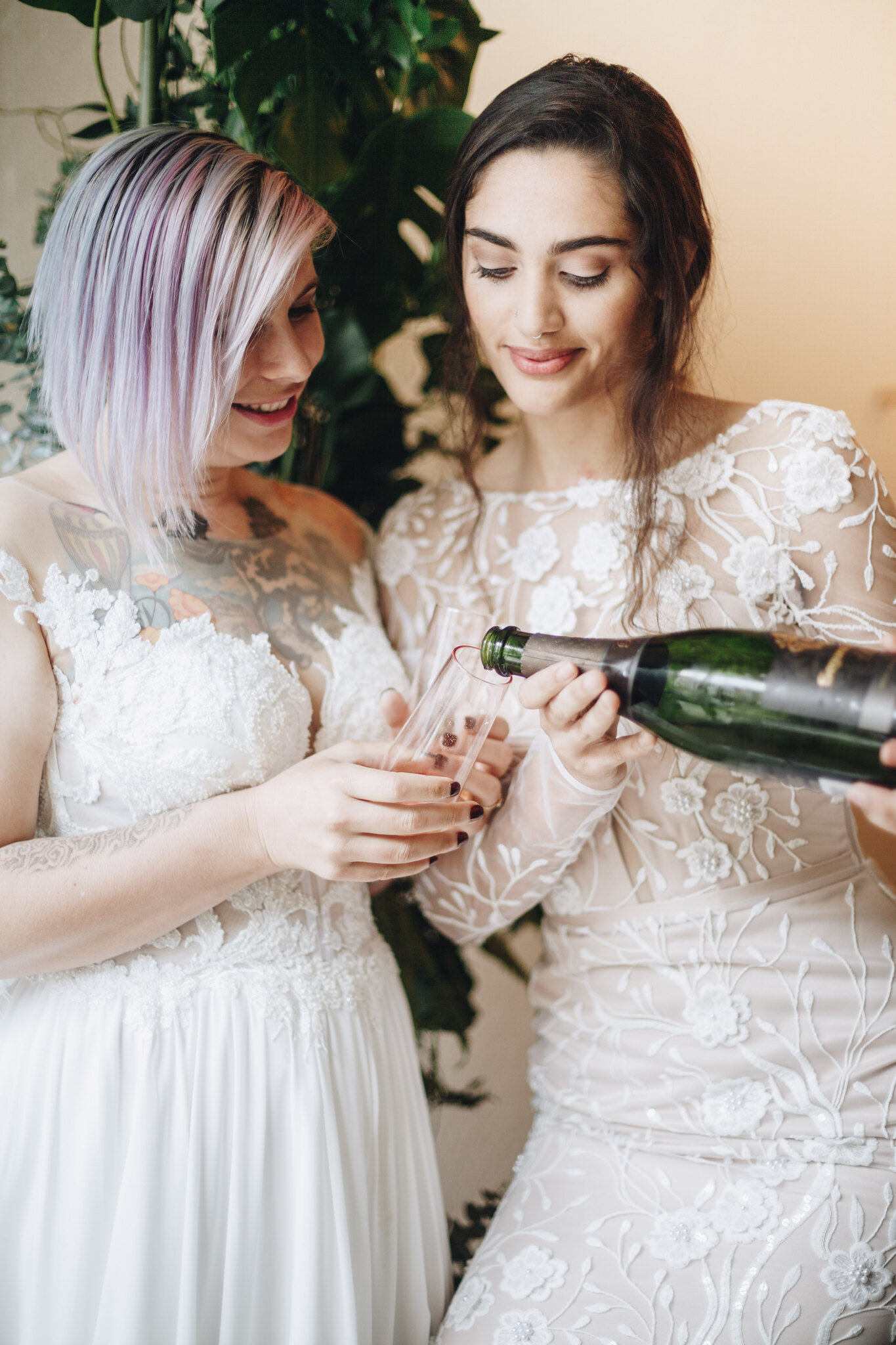 A woman pours champagne into another' woman's glass