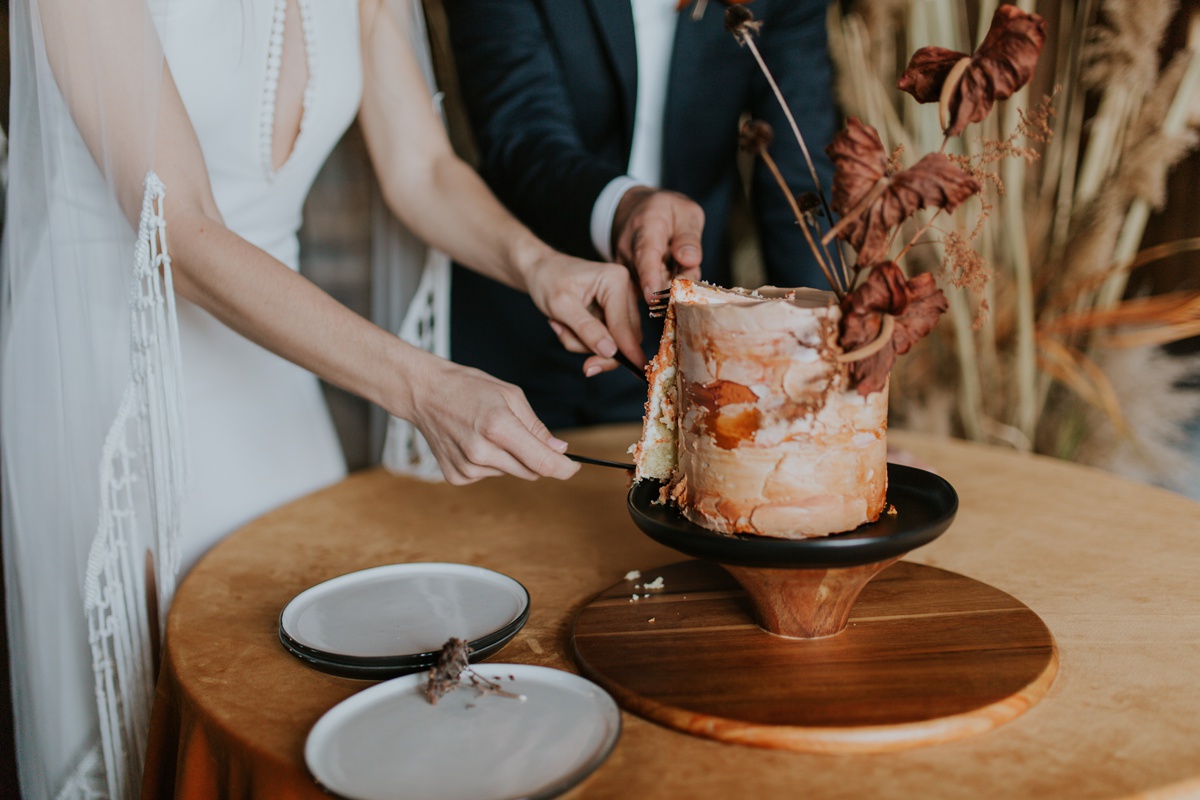 A wedding couple cut into a wedding cake