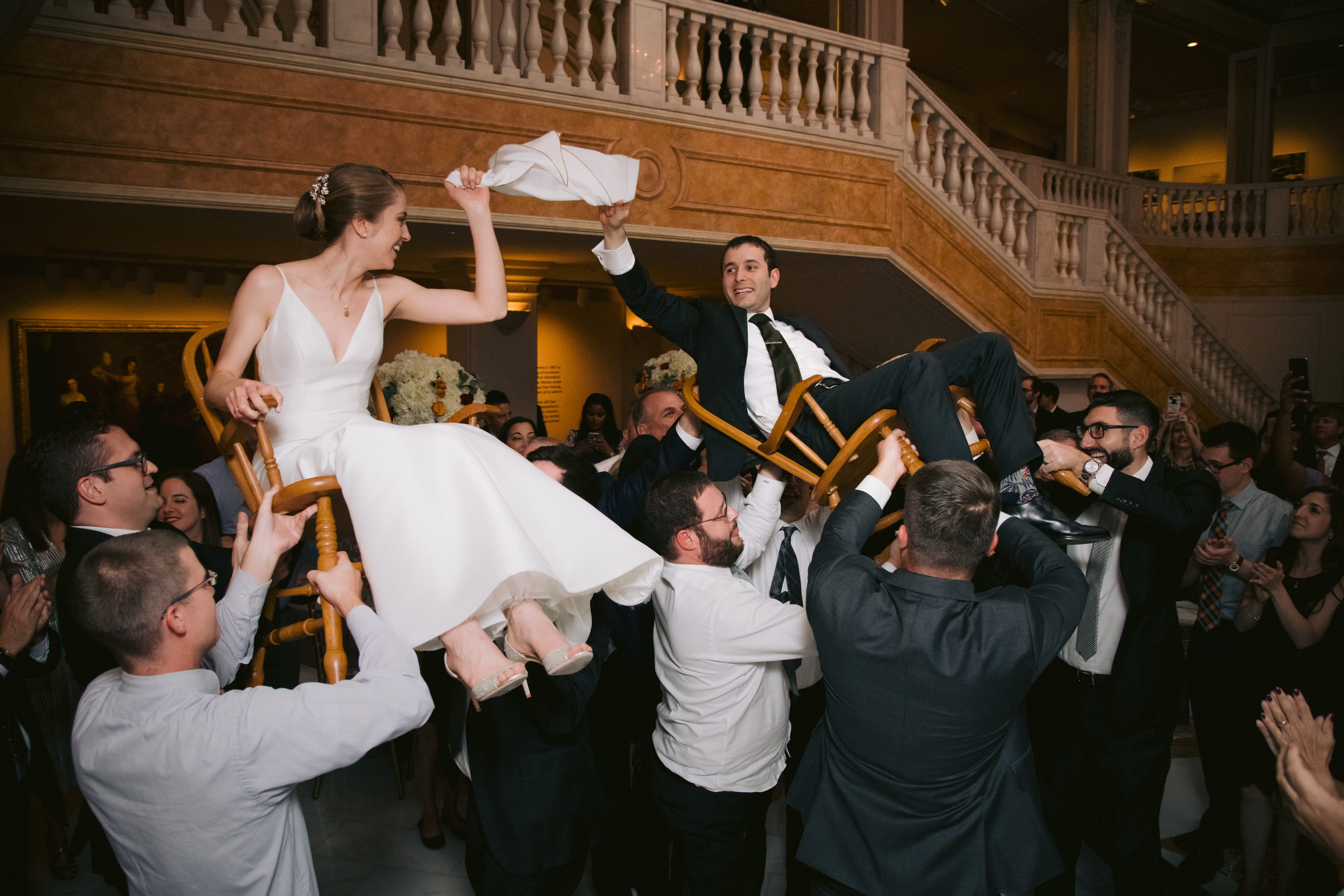 A Jewish wedding couple are lifted up in the air. Wedding planning timeline.