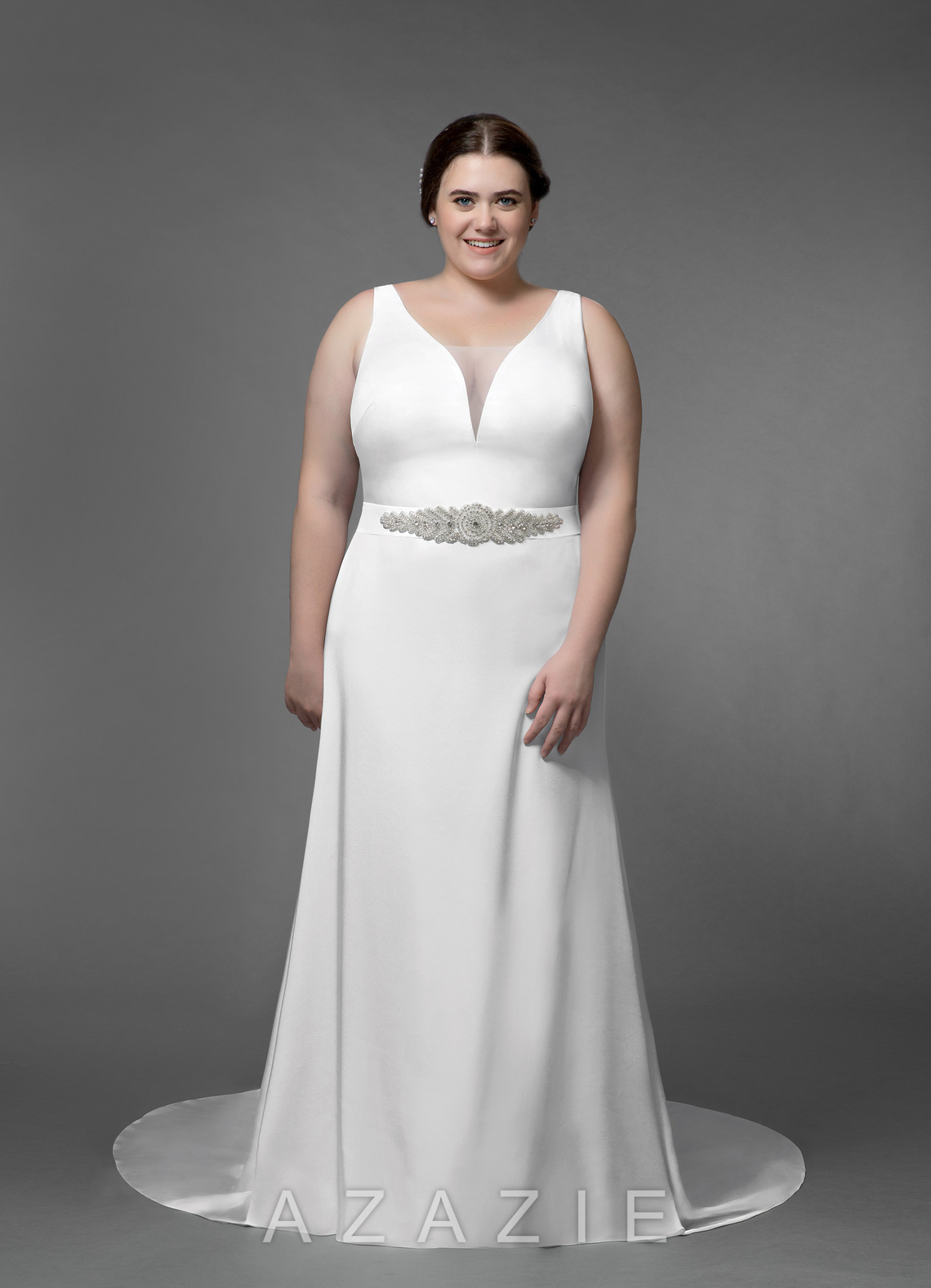plus size woman wearing a sleeveless belted wedding gown