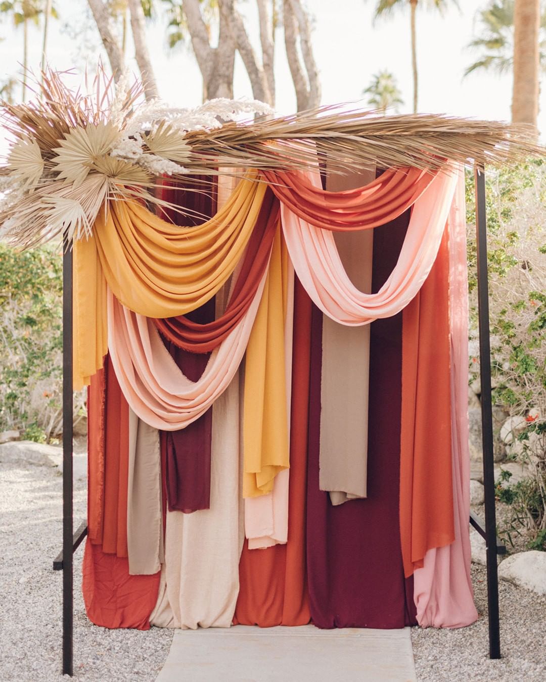 Cloth draped over a metal frame with fall wedding colors in mind