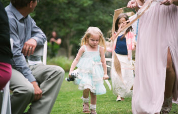 A child walks down the aisle with a very angry expression on her face.