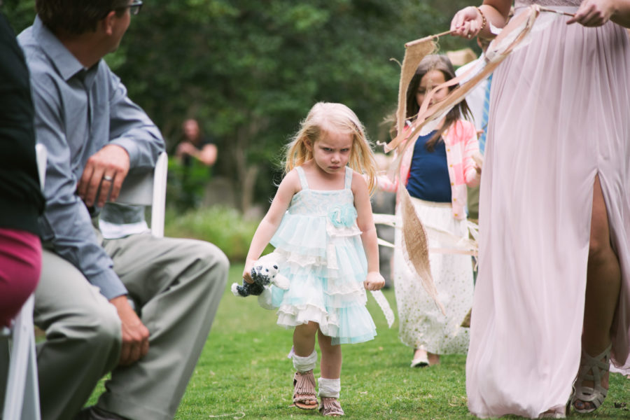 A child walks down the aisle with a very angry expression on her face.