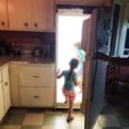A child walks through the fridge door at Meow Wolf