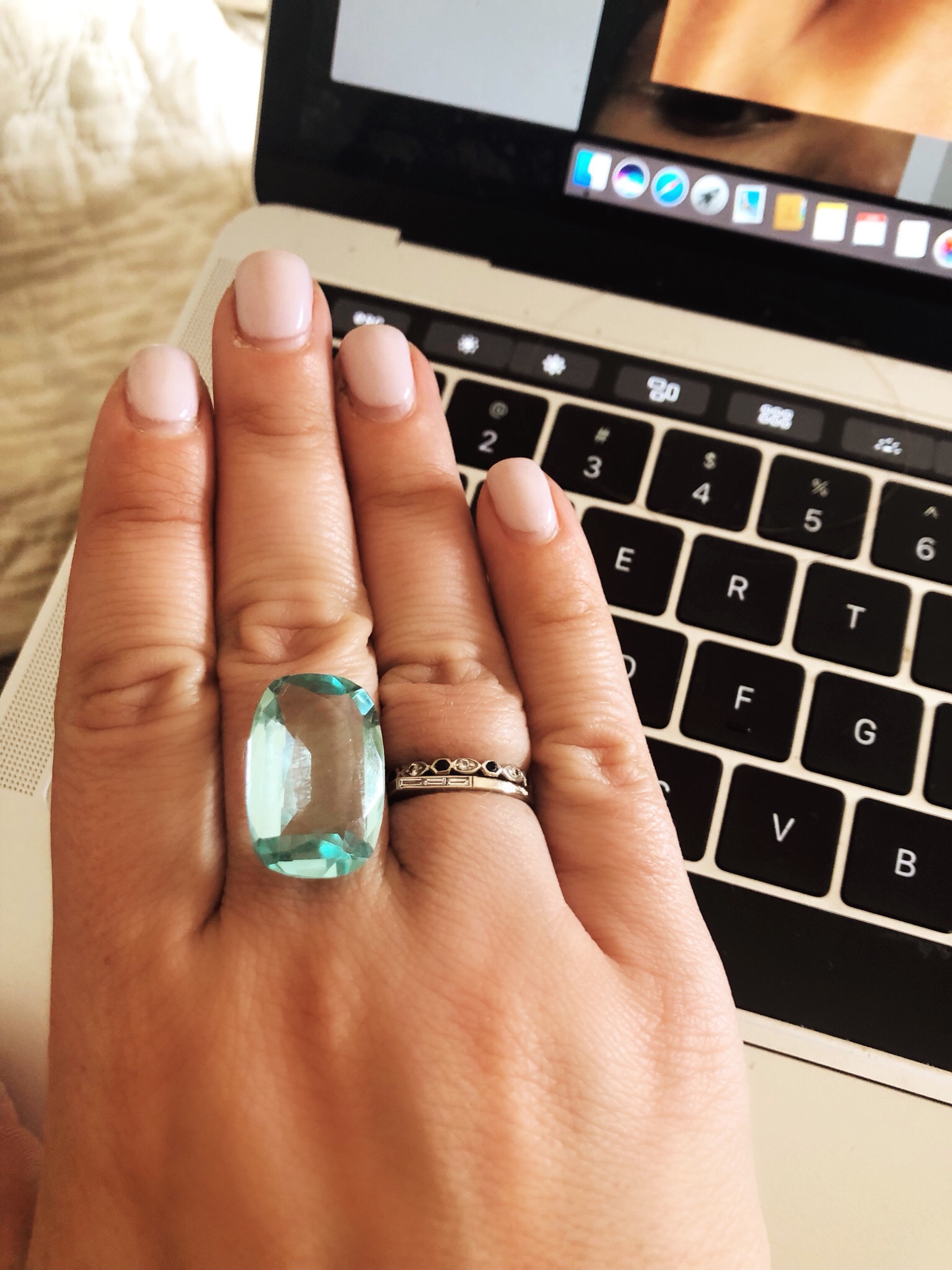 A hand wearing a ring over a laptop. 