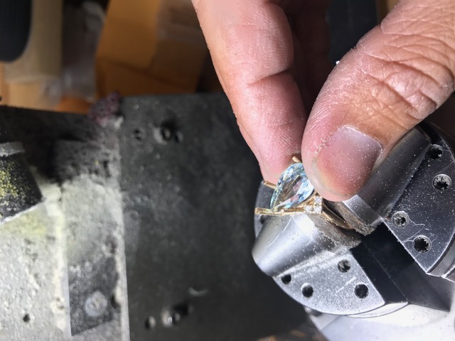 A stone being set in jewelry.