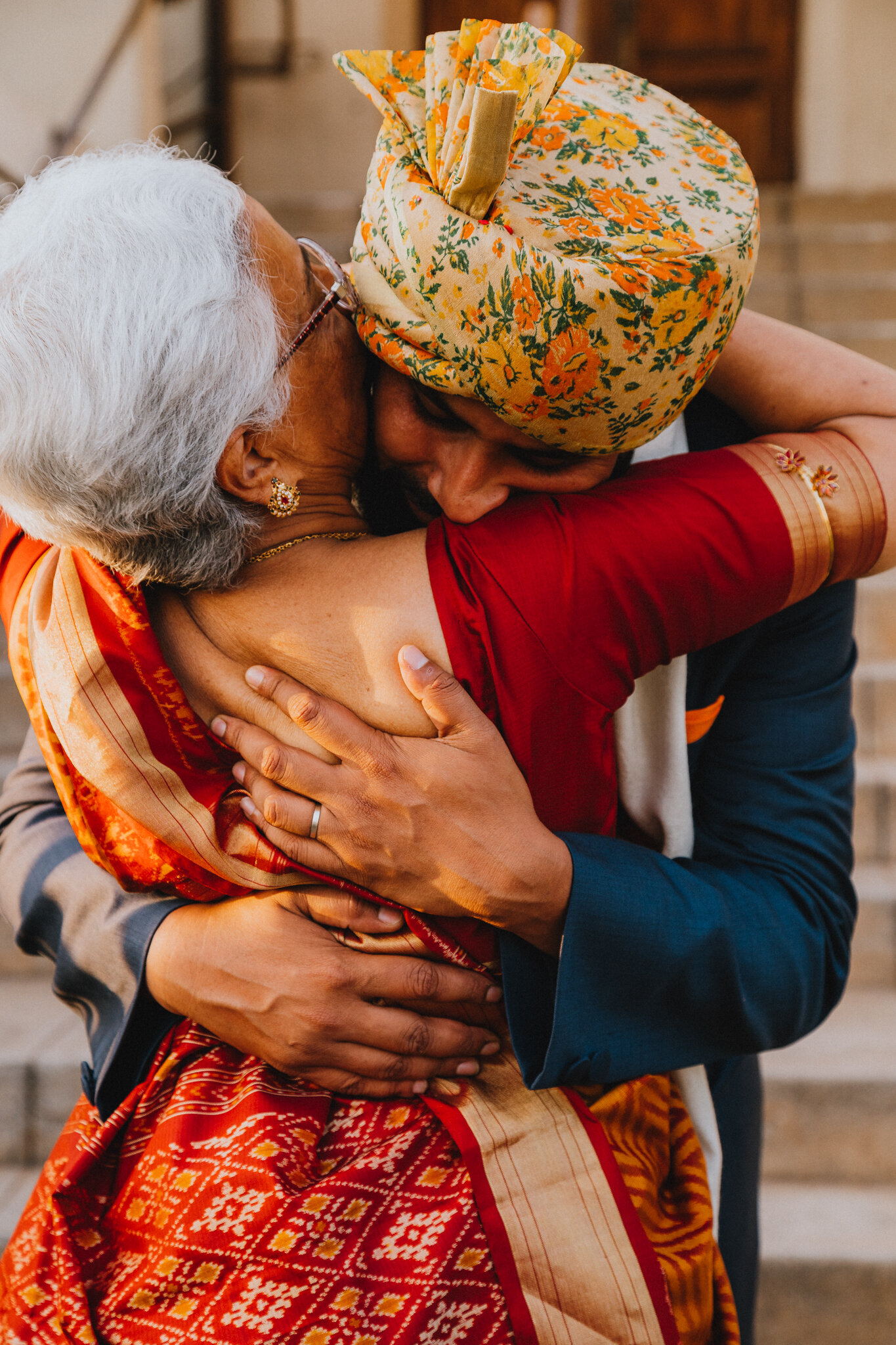 An elder woman embraces her son.
