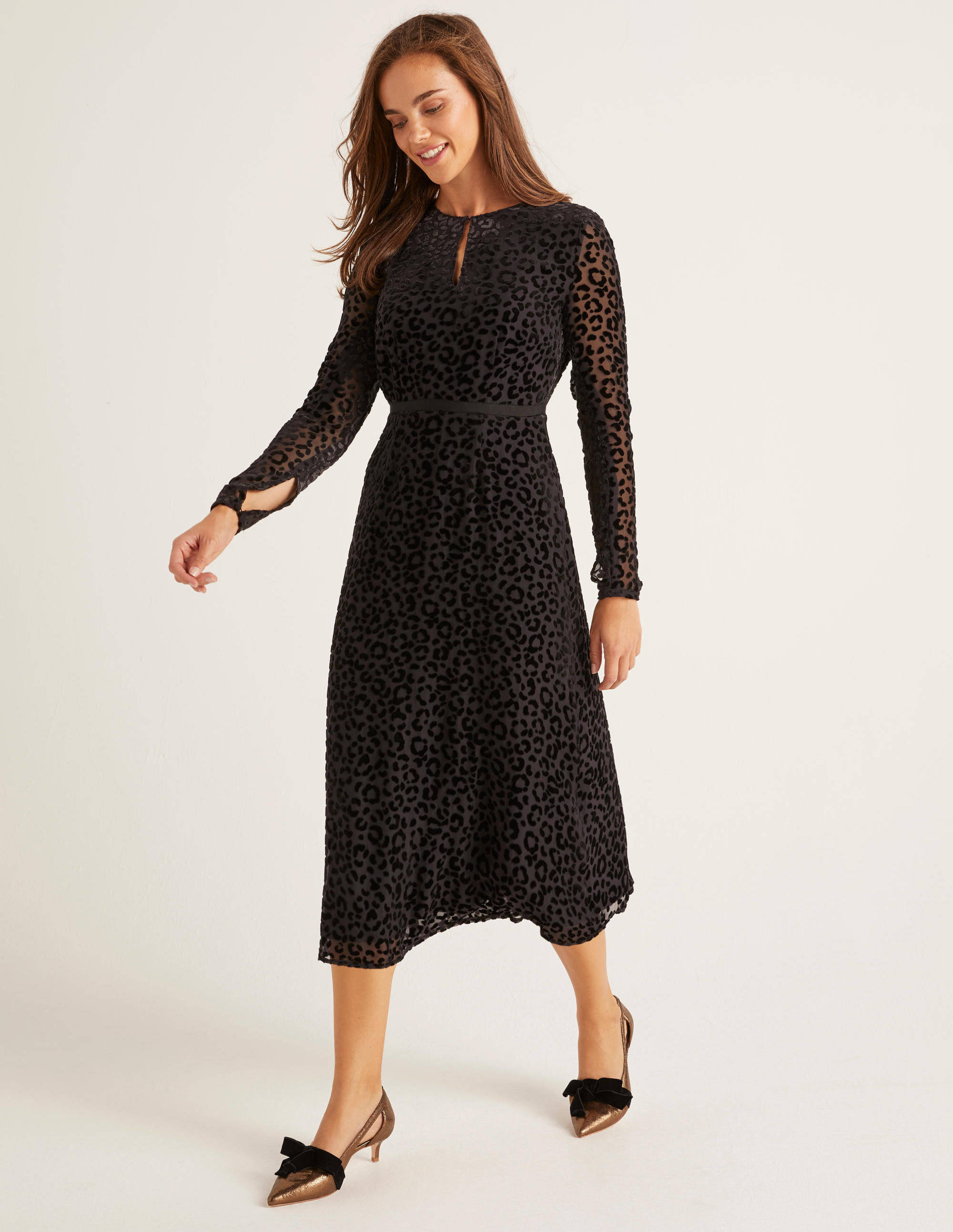 A model wears a dress described as being Crafted from silky viscose and covered in velvety leopard print, this on-trend midi dress is a statement staple. 