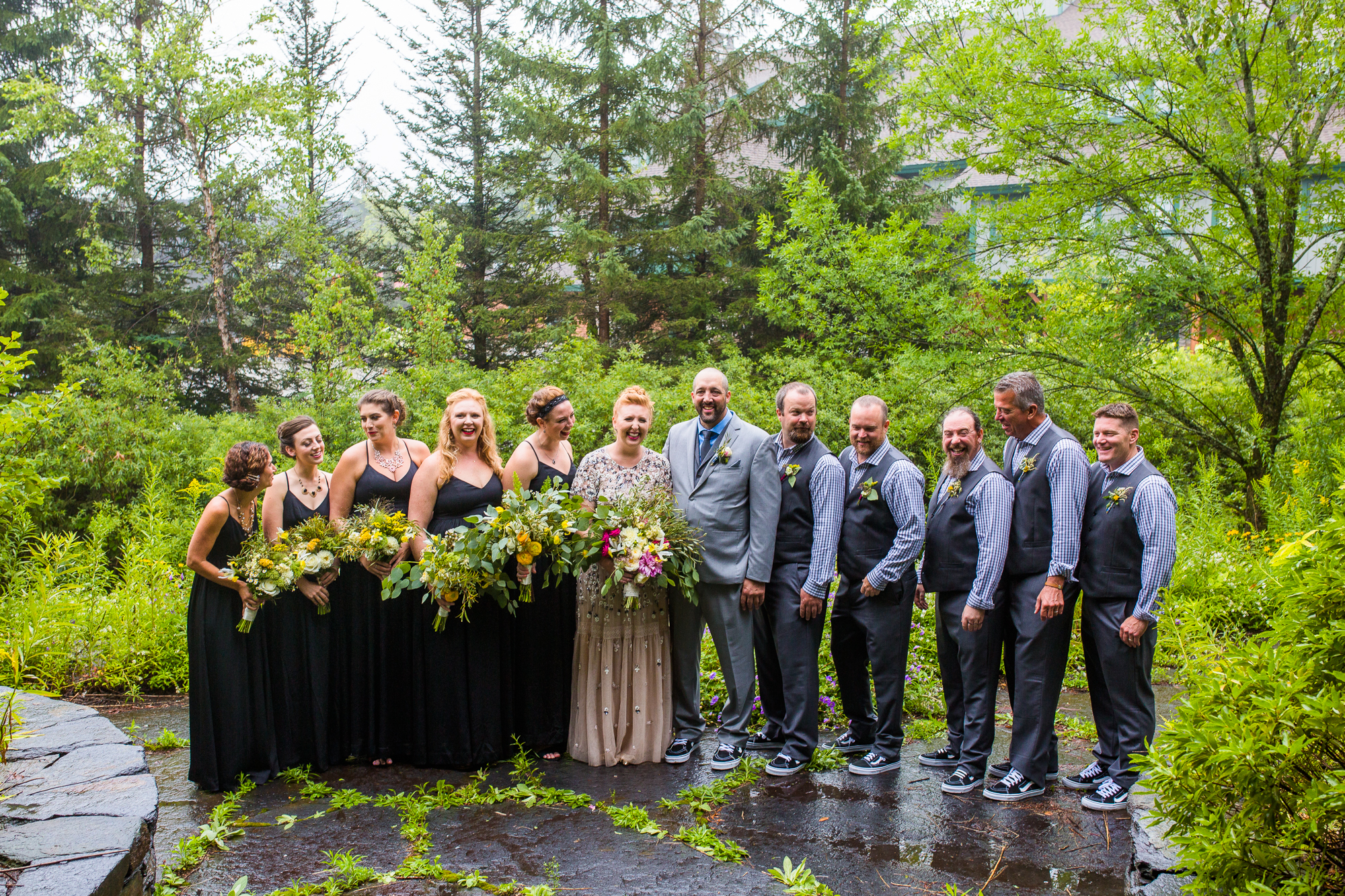 An entire wedding party stand in a line for a photo.
