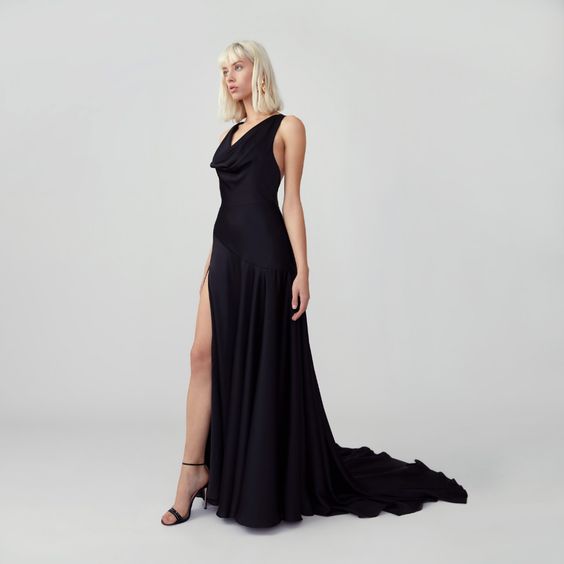 A woman wears an elegant full length black gown. Black wedding dresses.