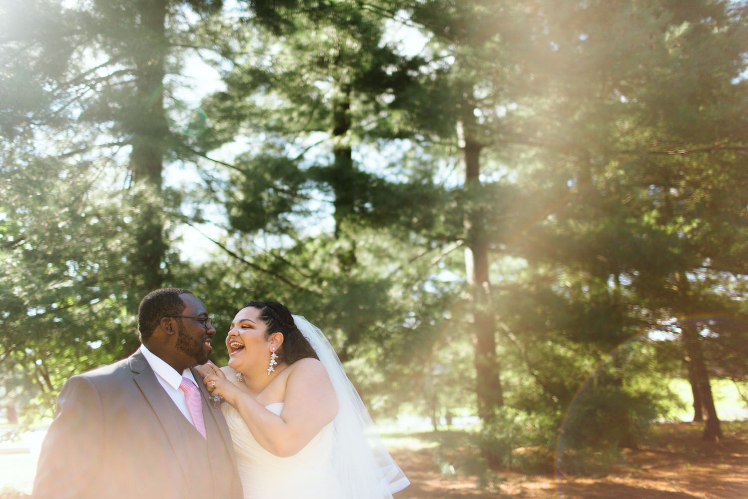 A wedding coupe laugh and smile in the forest.