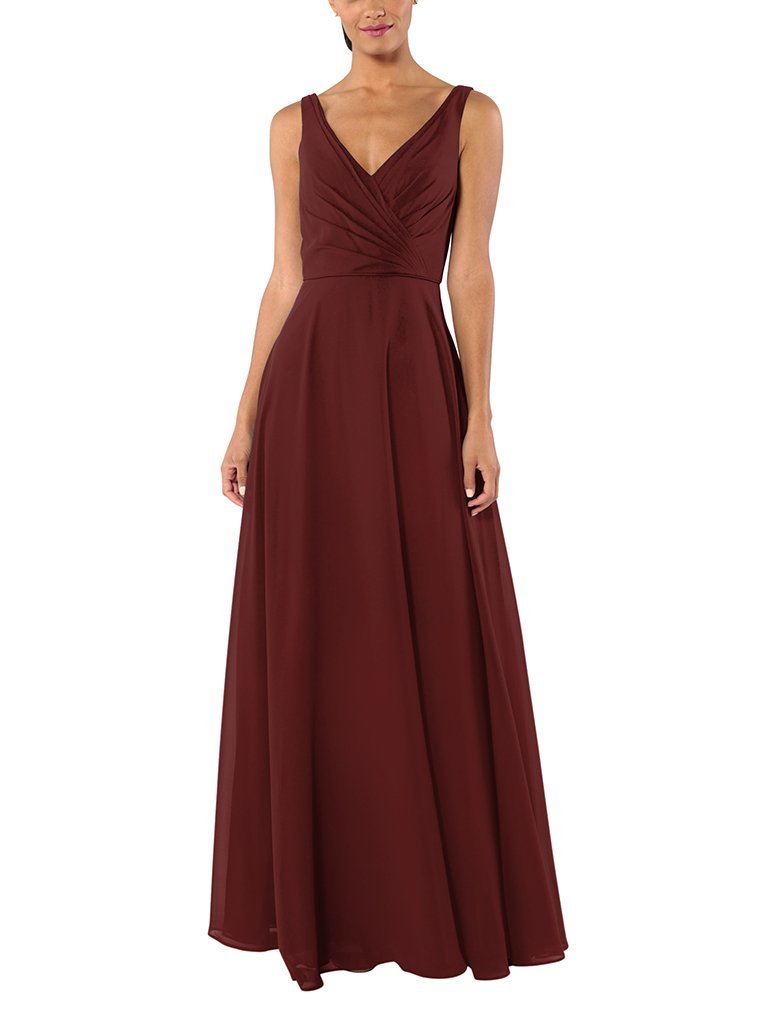 A woman stands wearing a maroon bridesmaid dress.