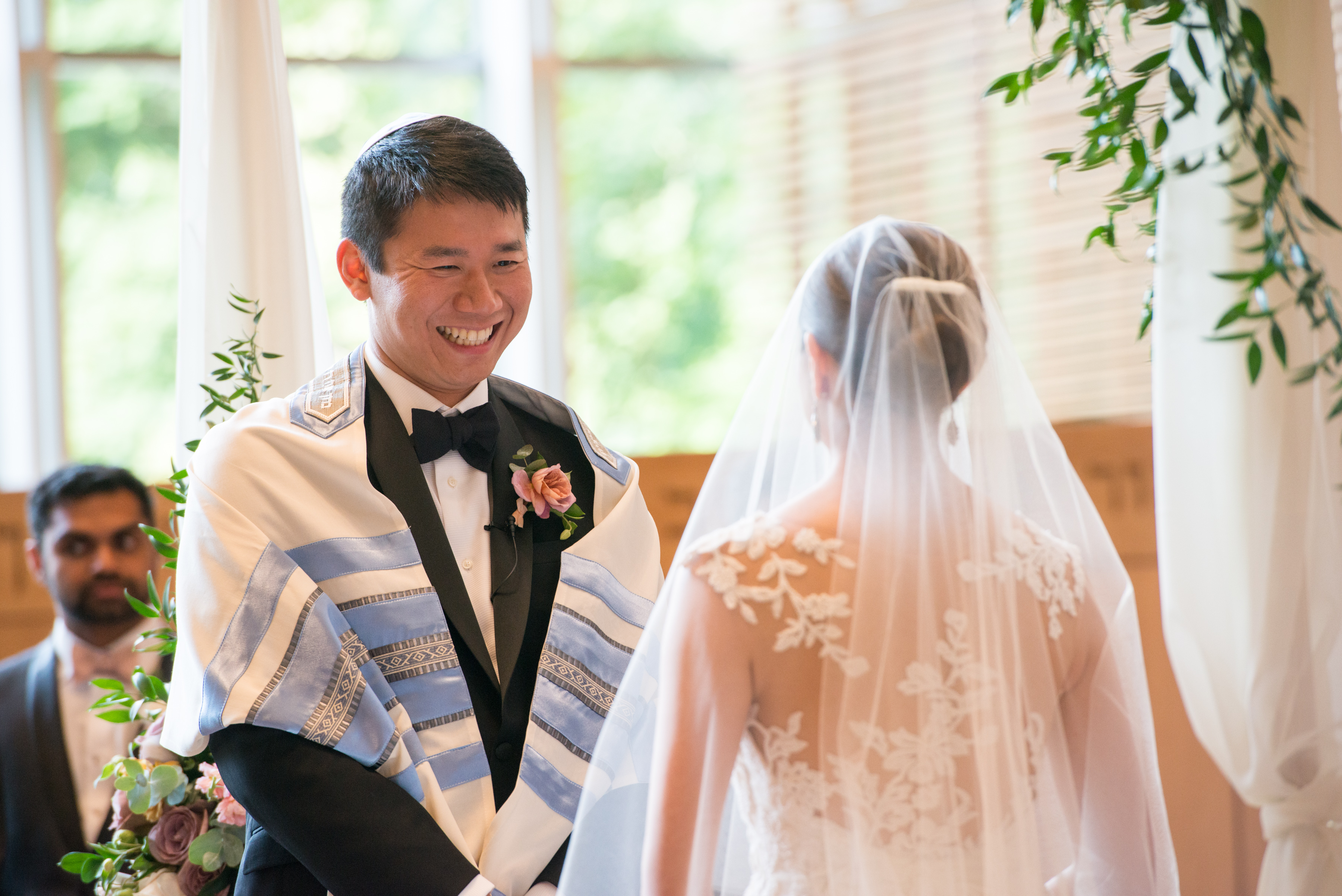 A man smiles at his bride during their wedding ceremony.