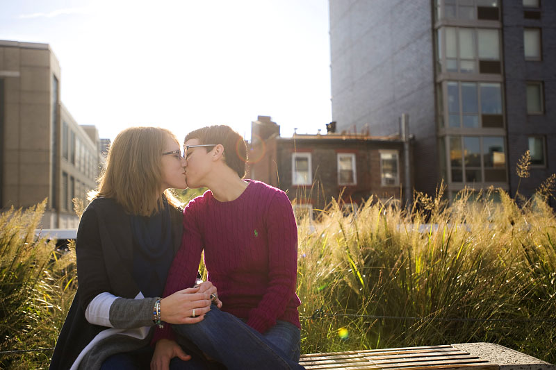 A couple kiss on a bench. Proposal ideas.