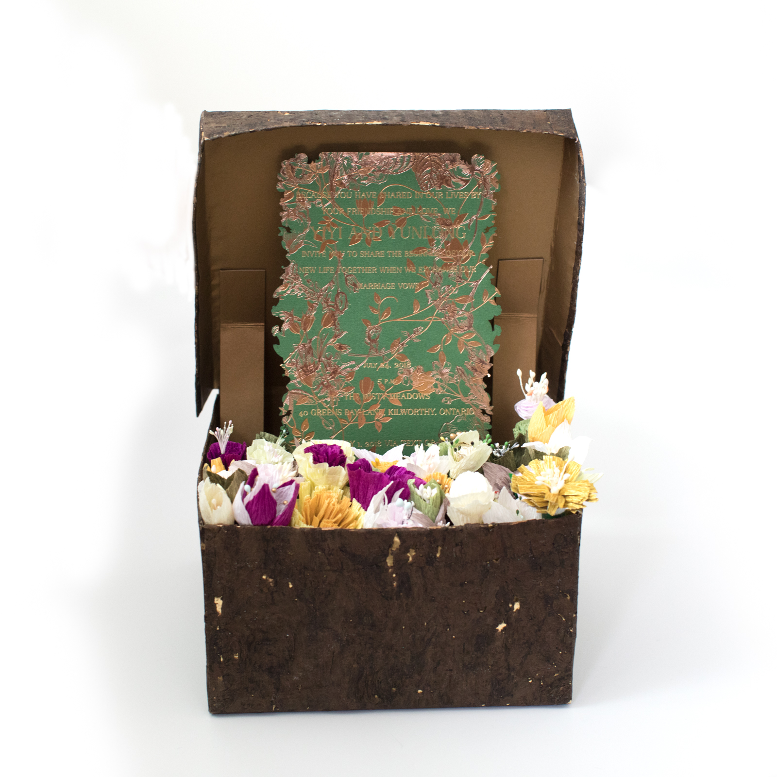 An invitation in a box full of flowers.