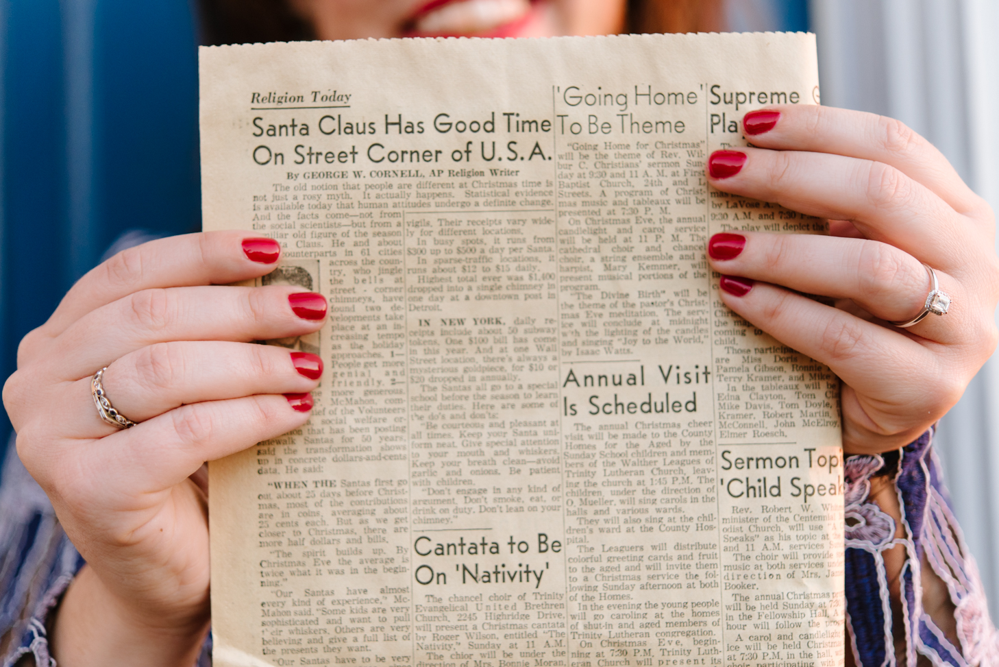 Woman holding vintage holiday newspaper