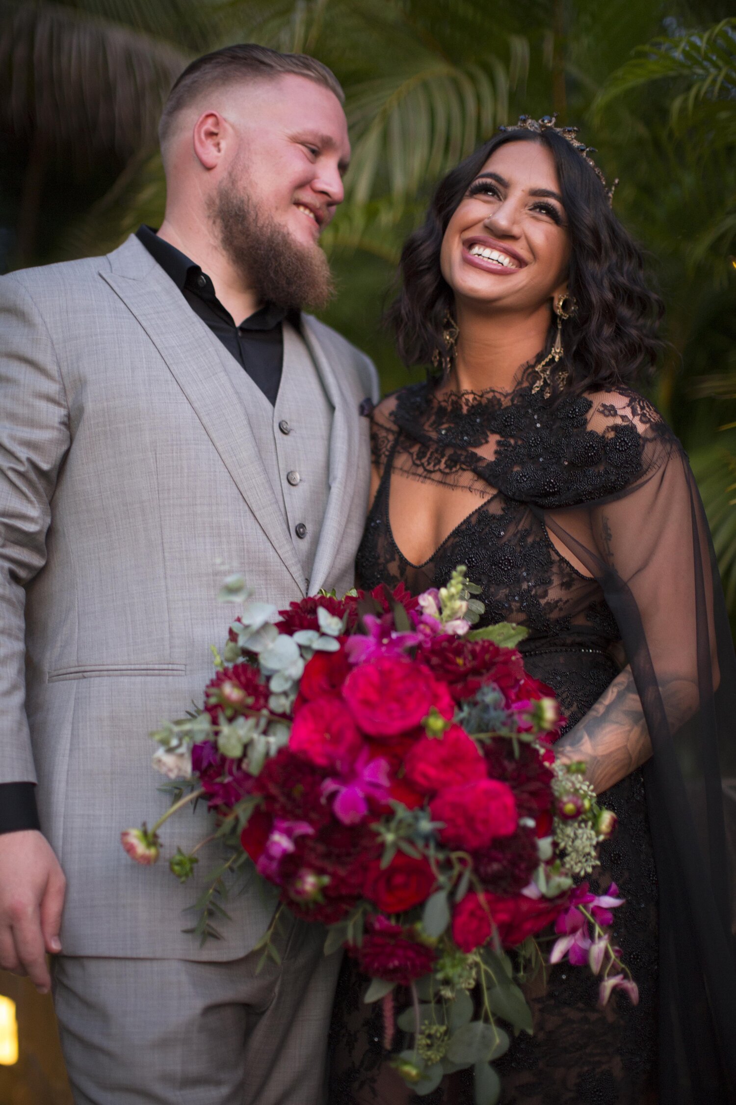 A wedding couple stand together and smile.