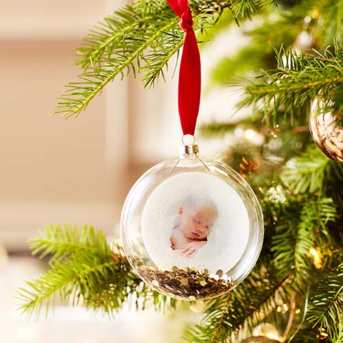 A holiday ornament with a photo inside.