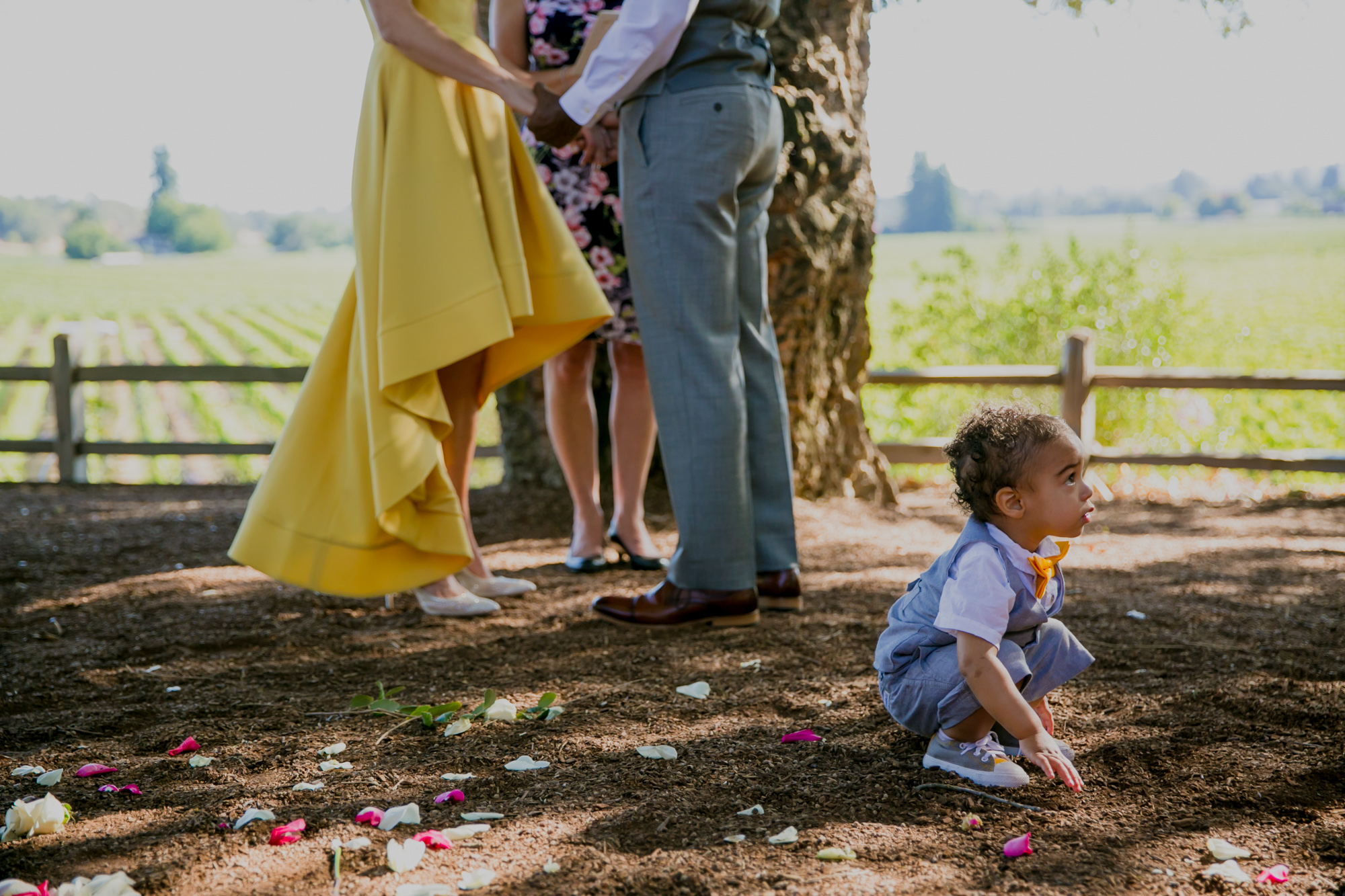 A child plays on the ground during a wedding ceremony.