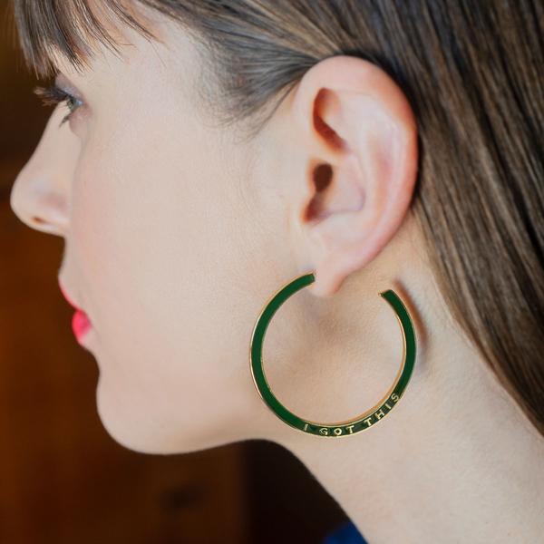 A green hoop earring with "I Got This" printed on it.