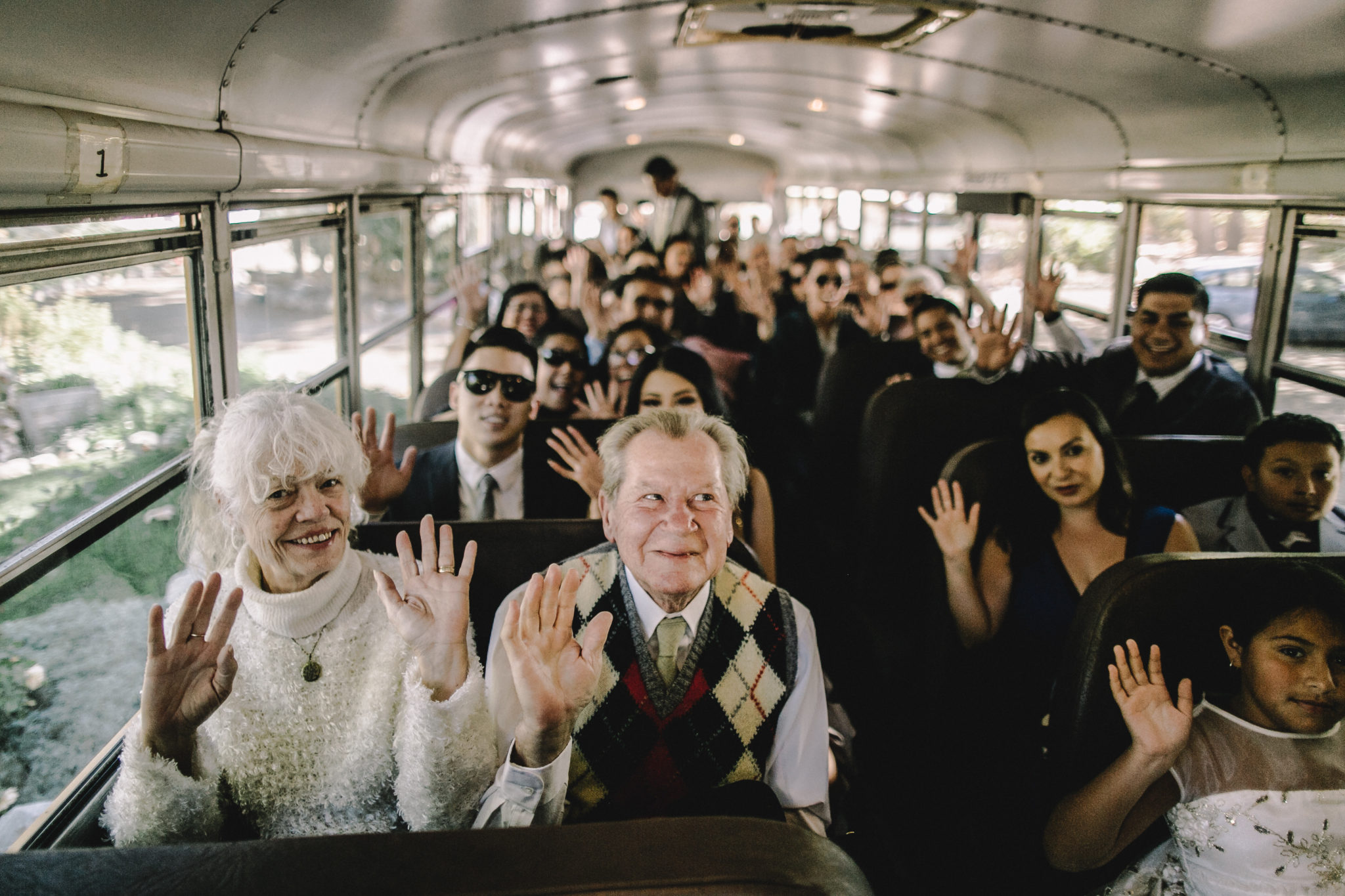 bus full of people of all ages, older couple at the front in focus