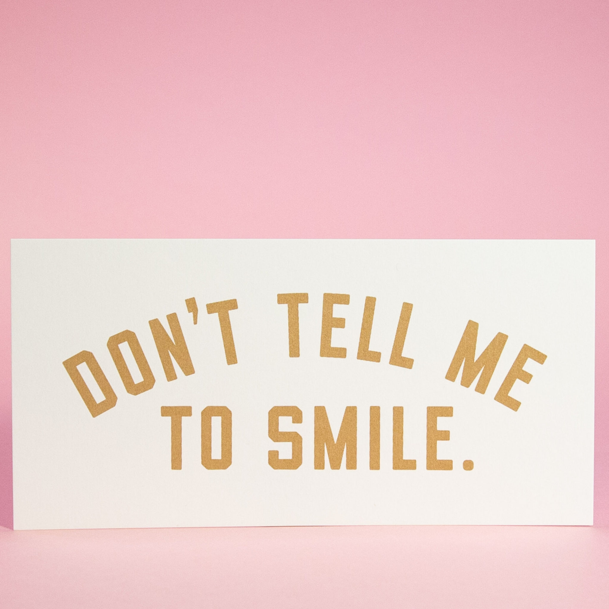 A sign that says "Don't Tell Me to Smile."