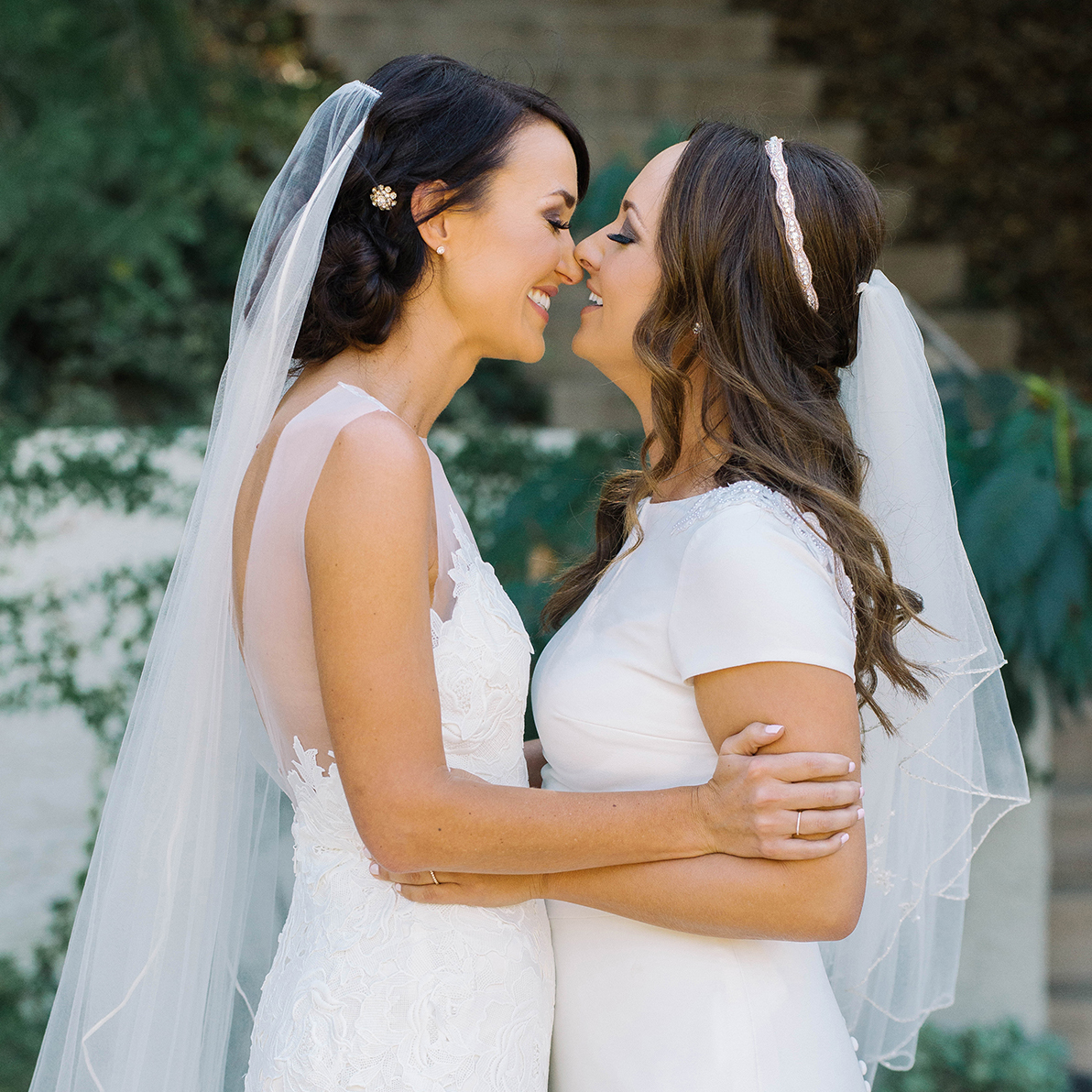 Two women are about to kiss on their wedding day.
