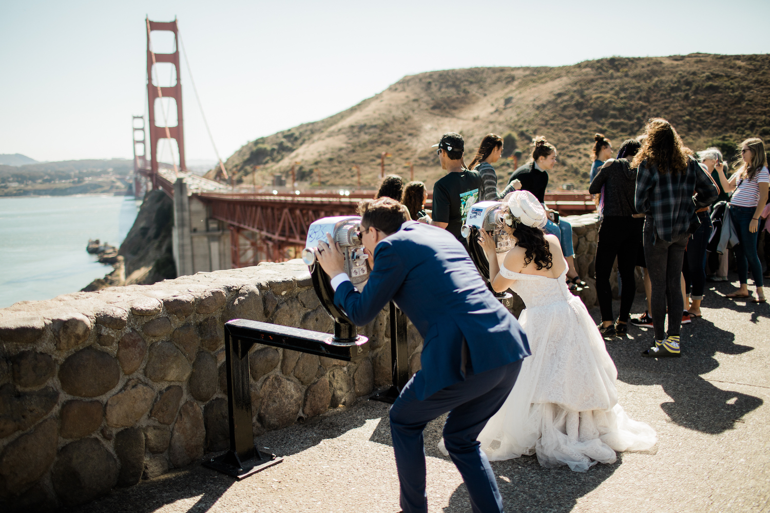 A wedding couple view the Golden Gate Bridge through view finders.