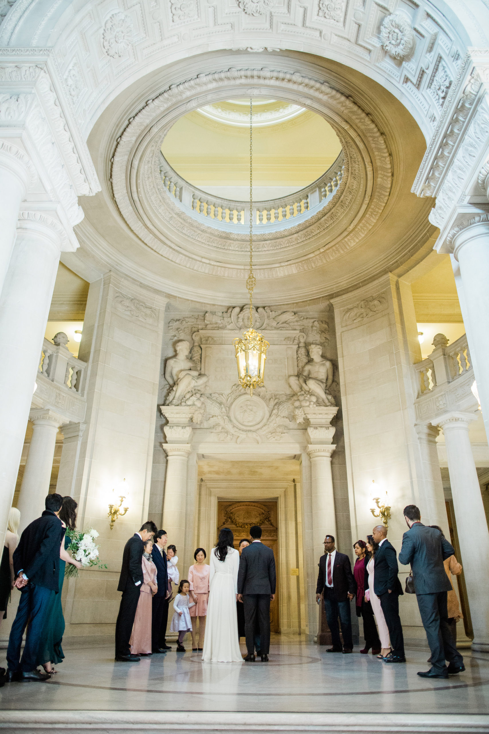 A wedding couple have their ceremony in the center of City Hall.