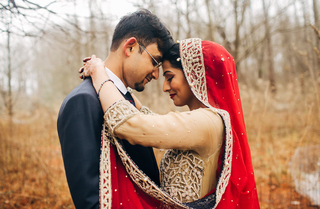 A wedding couple hugs while in the forest.