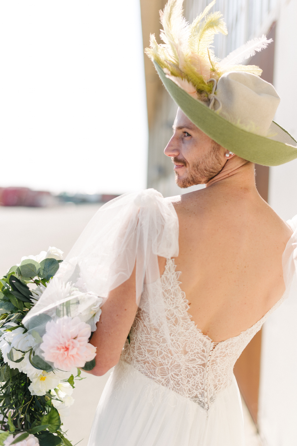 Photo of a man's back as he wears a wedding dress.