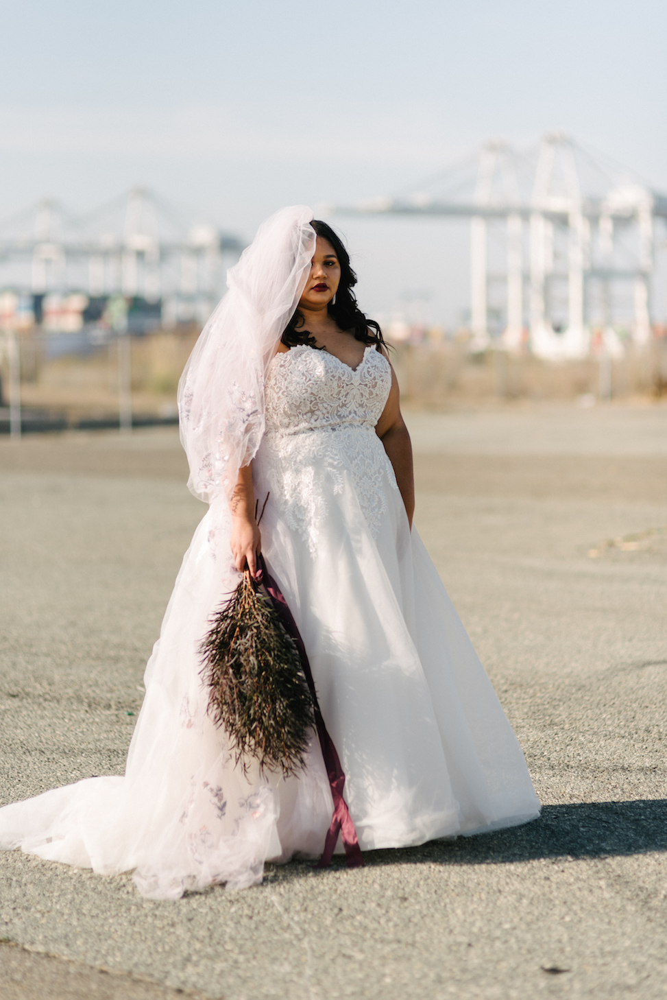 A women wears Maggie Sottero dress style 'Vanessa' with a veil and a bouquet.