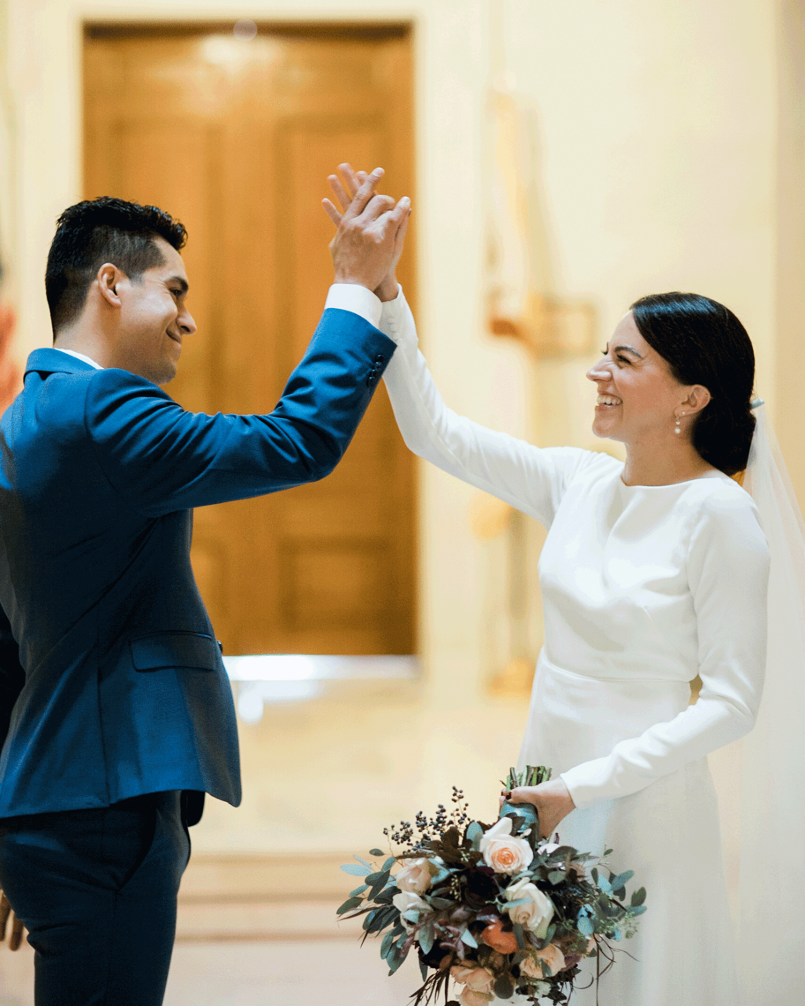 Animated gif of a wedding couple hi-fiving each other.