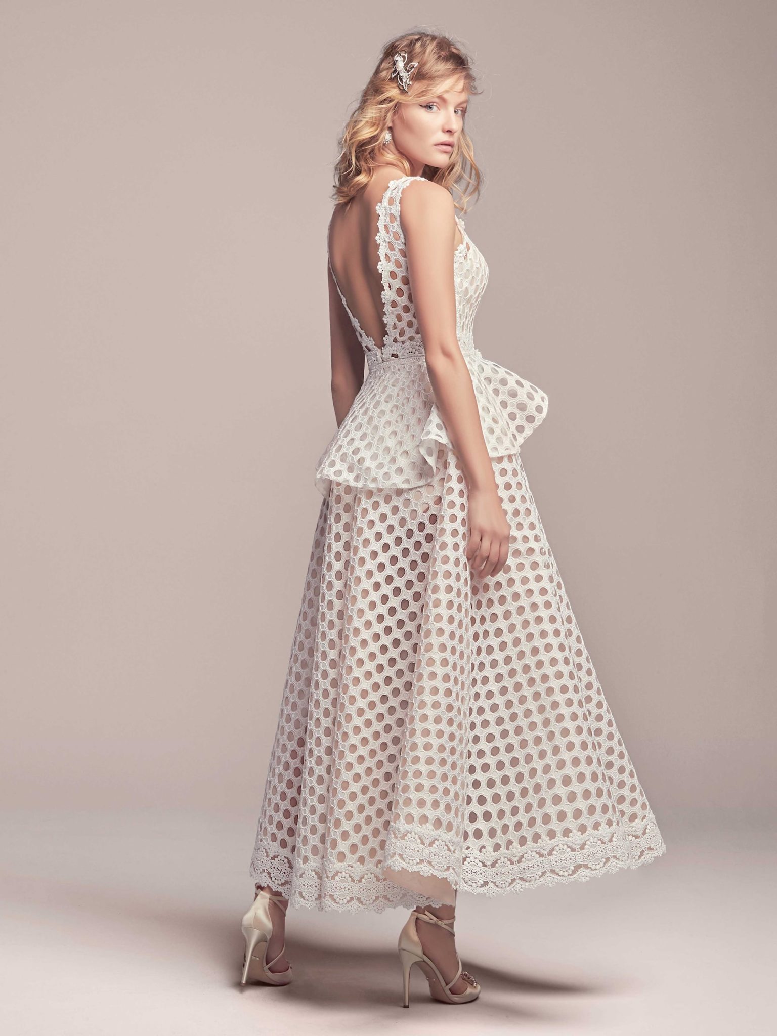A woman wears a wedding dress with polka dots.