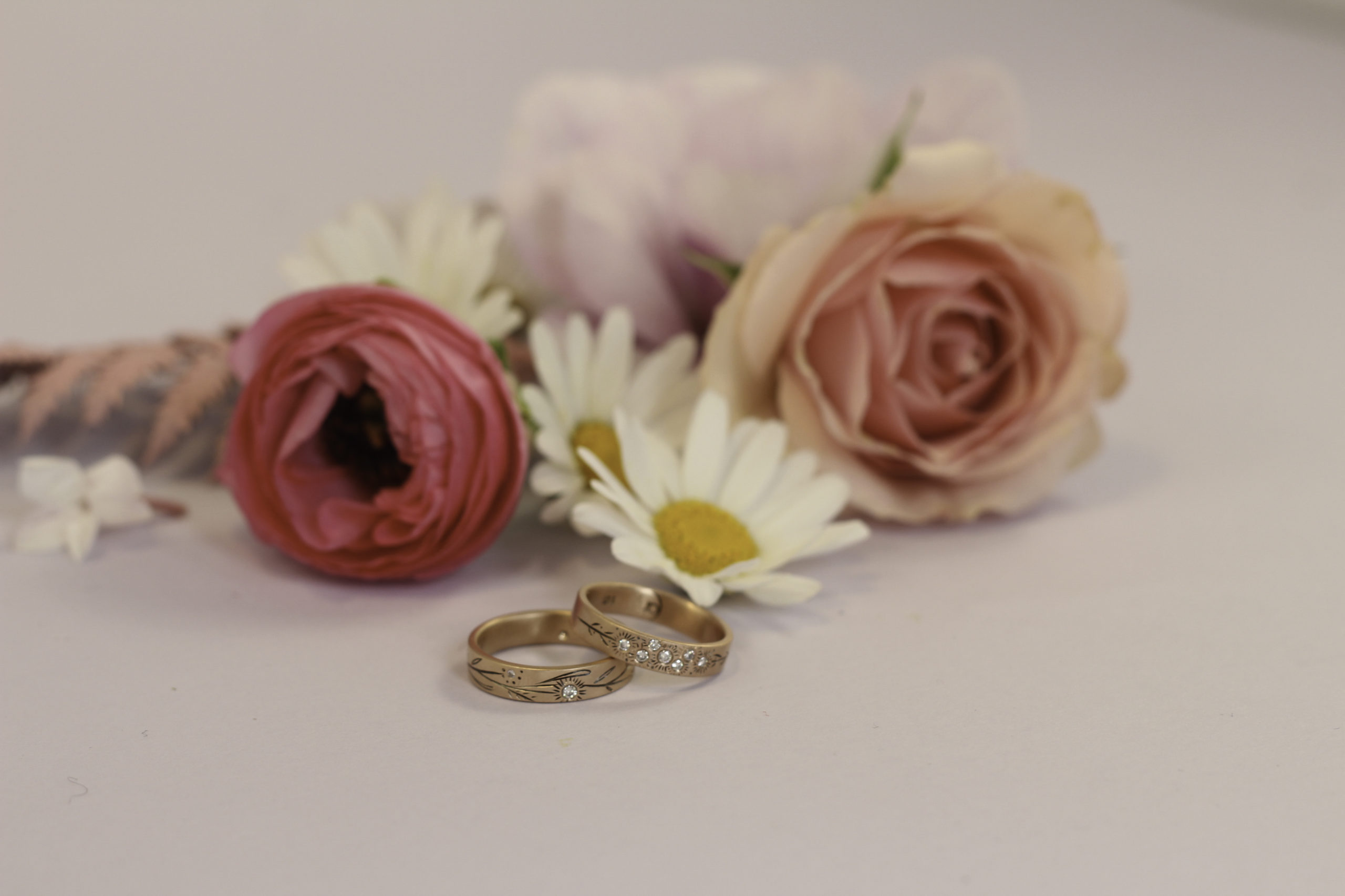 Two rings set down near flowers.