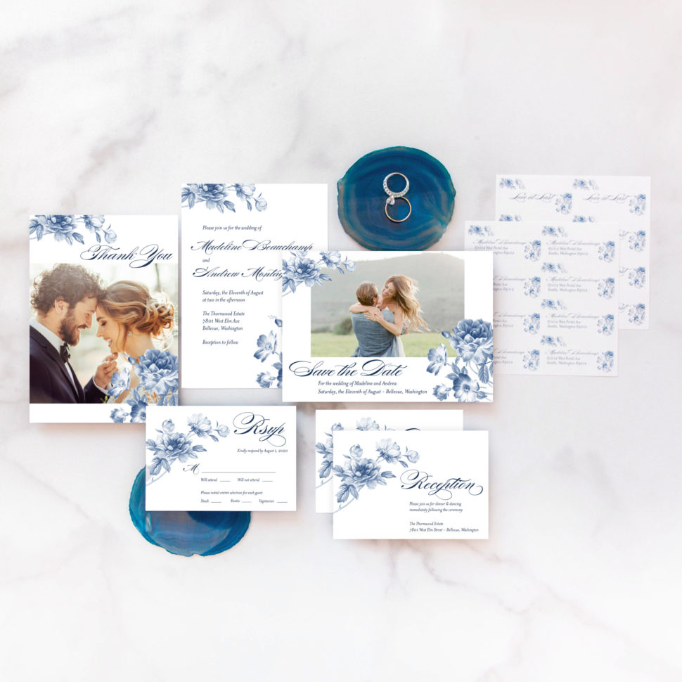 Flat lay of the complete Floral Wedding Suite from the Martha Stewart for Mixbook Collection featuring rings, an invitation, rsvp card, thank you card and more.