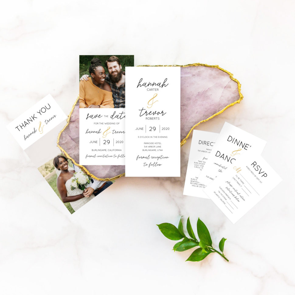 Flat lay of the complete Simple Wedding Suite from the Martha Stewart for Mixbook Collection featuring rings, an invitation, rsvp card, thank you card and more.