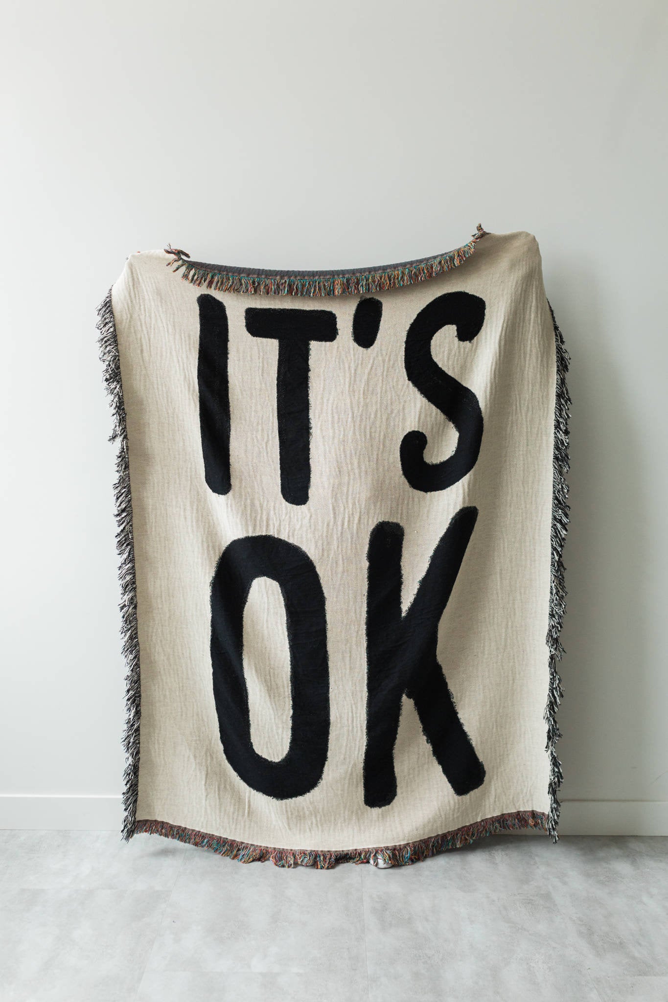 white and black blanket that says "it's ok"