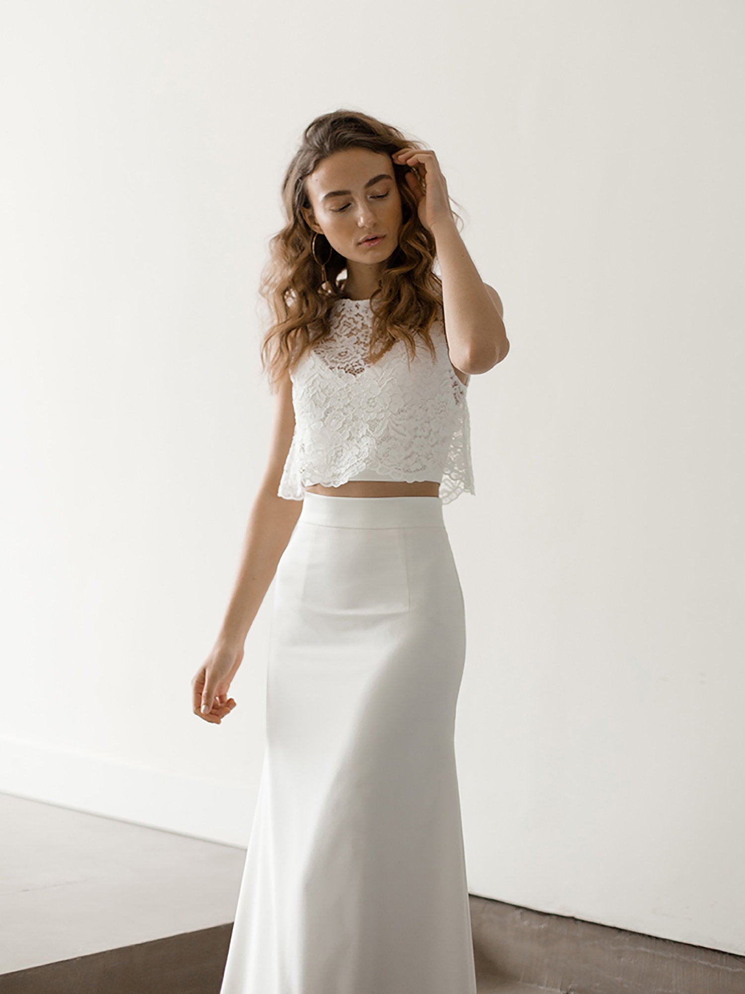 A model wears wedding separates with a lace top.