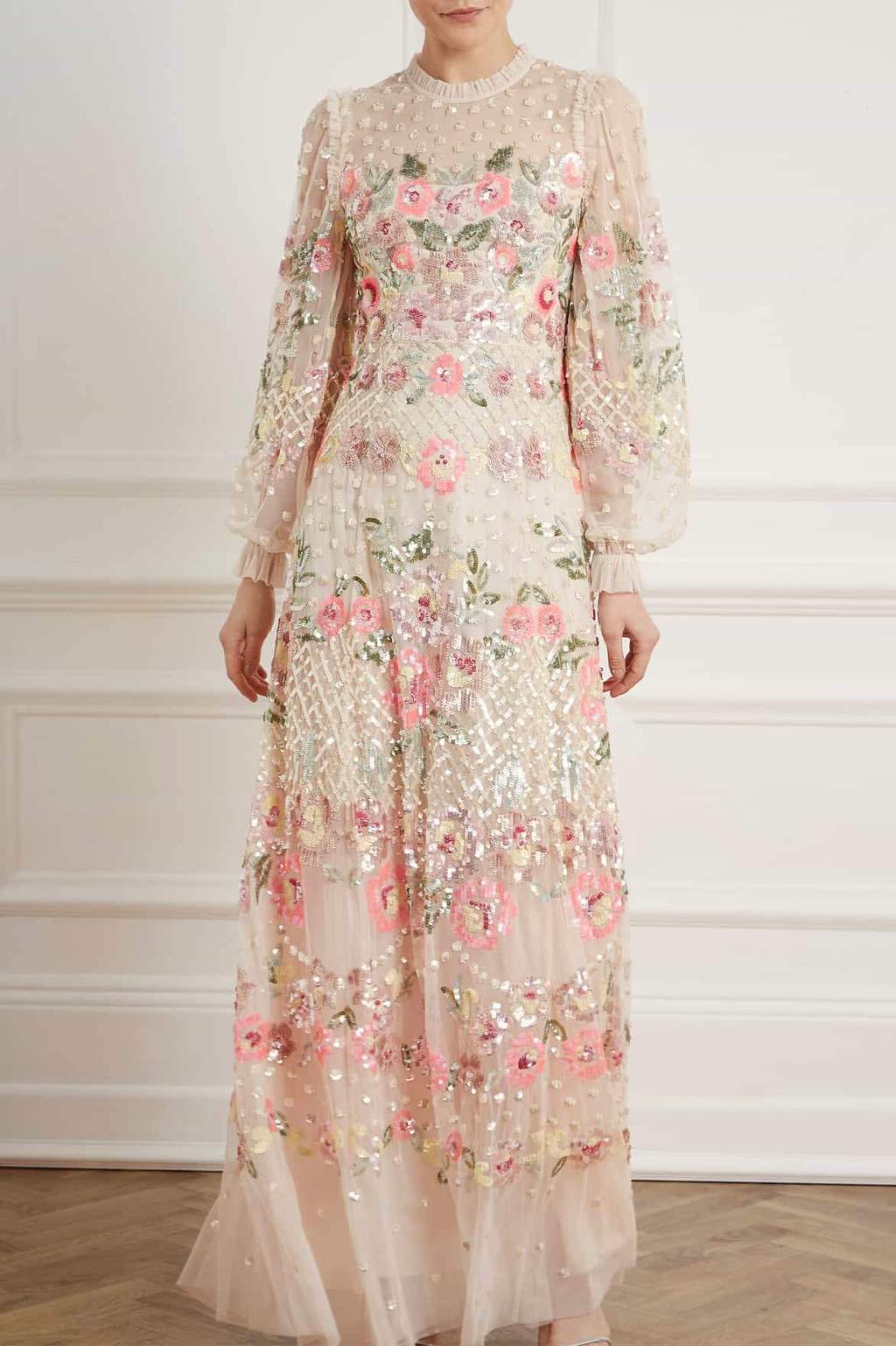 Woman in cream and pink floral sequin lace gown with long sleeves