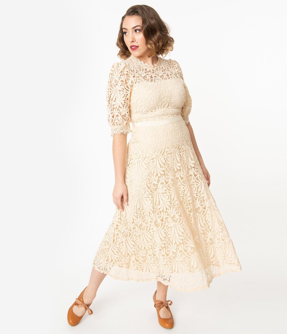 Woman with dark hair in cream colored lace wedding dress in vintage style