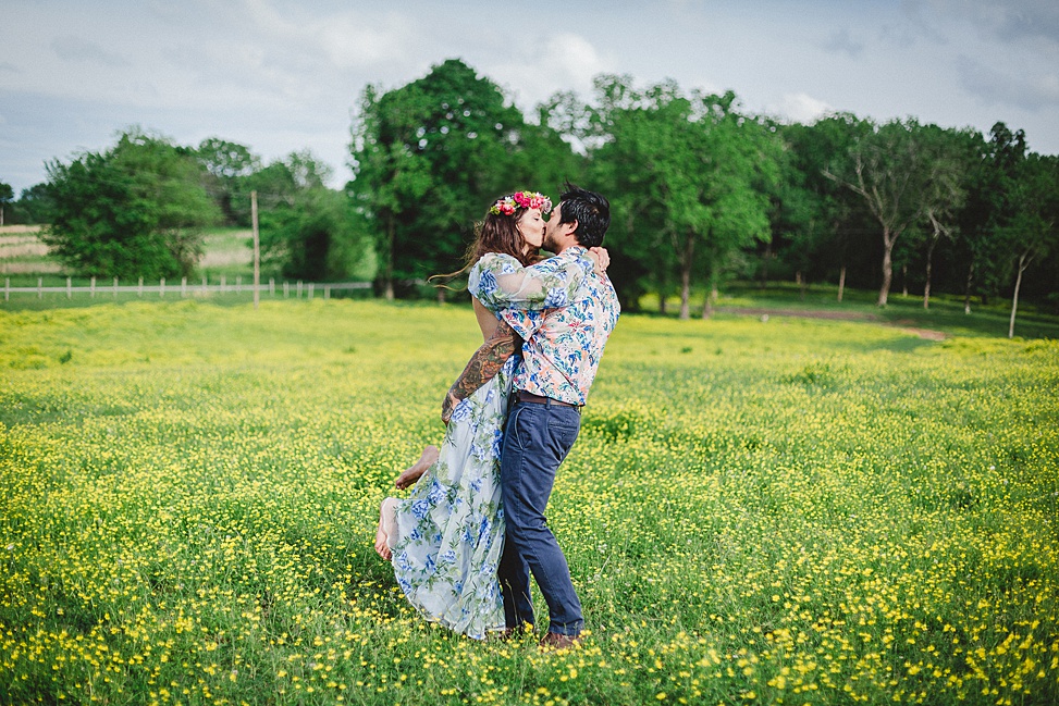 couple kissing in a field of flowers