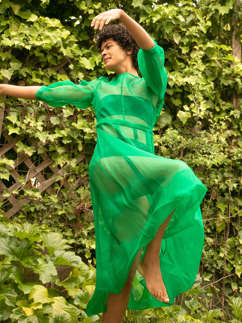 black womxn dancing wearing a kelly green dress