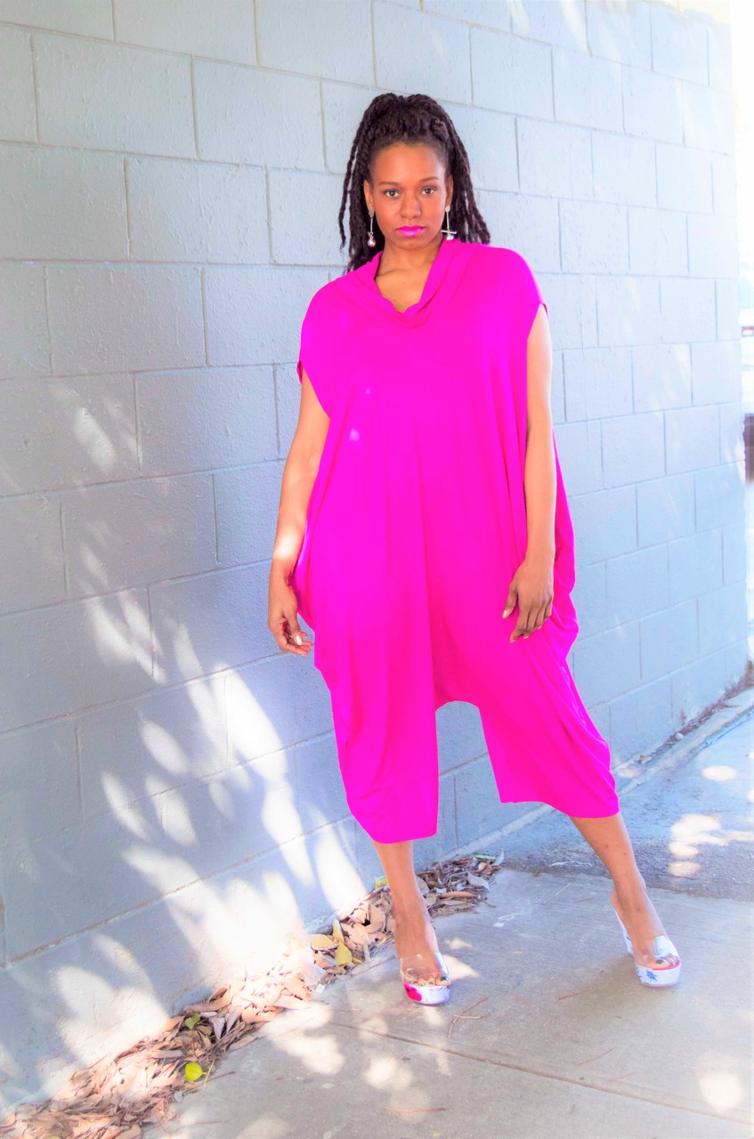 black womxn wearing a bright pink jumpsuit