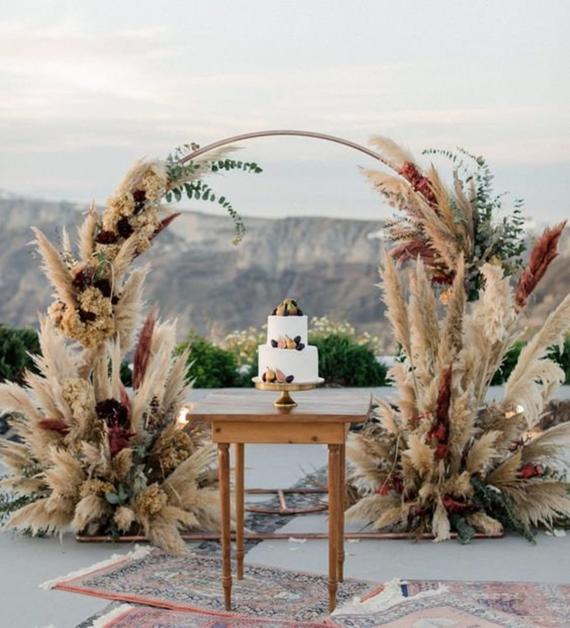 Round wedding ceremony arch with dried florals as backyard wedding decor