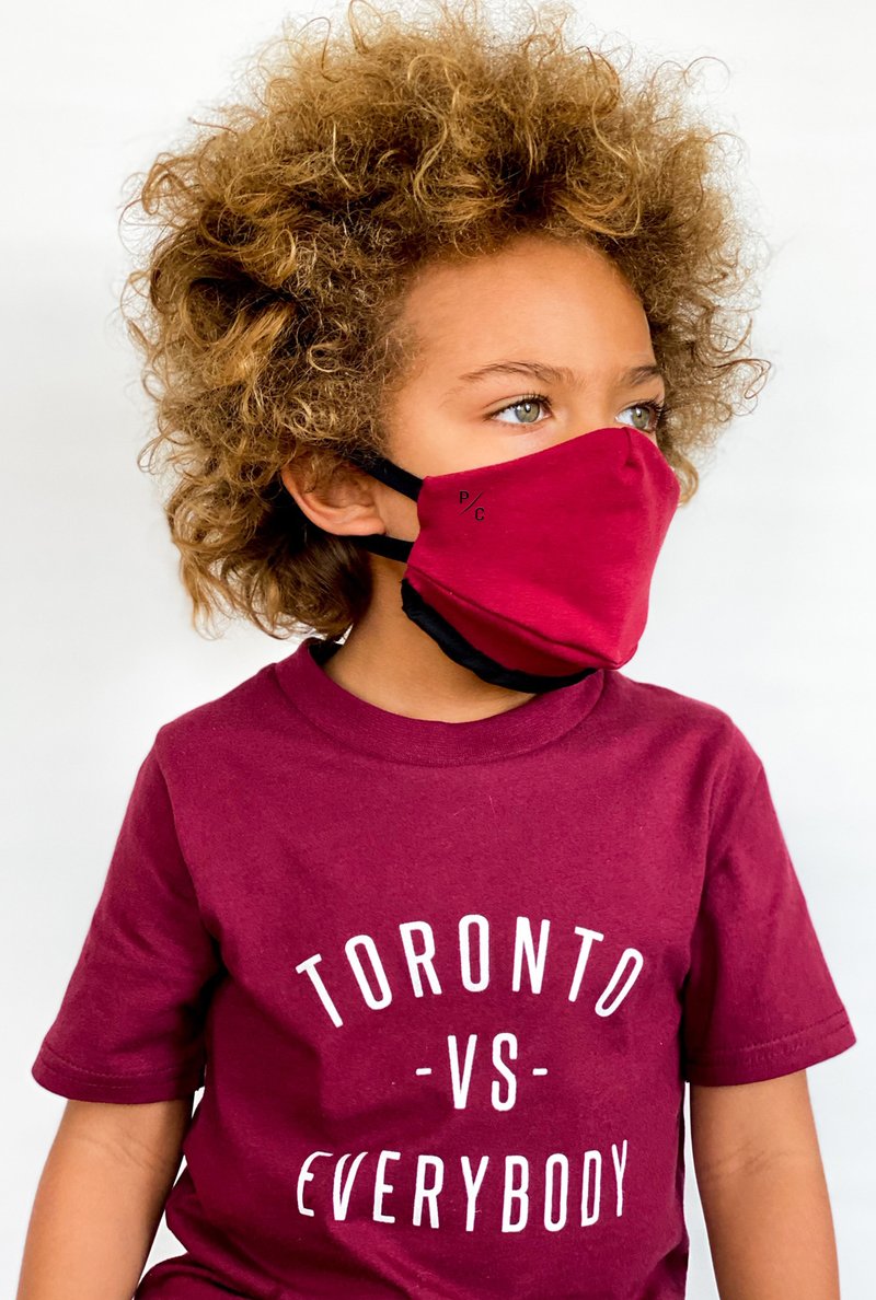 a child wearing a red reusable face mask